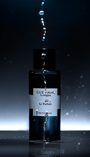 Hair Rituel by Sisley Le Parfum fekete üveg parfüm vízcseppekkel, luxus haj- és fejbőrápoló illat elegáns megvilágításban.