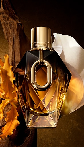 Rabanne Million Gold Parfum – aranyszínű, ékszerszerű parfüm üveg virágos és természetes háttéren, az új illat felfedezésére