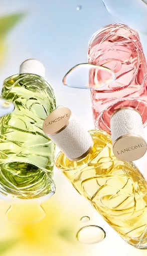 Lancôme parfümök zöld, rózsaszín és sárga üvegekben, elegáns fehér kupakkal – prémium női illatok