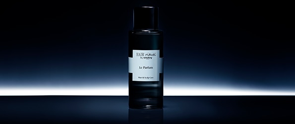 Hair Rituel by Sisley Le Parfum fekete üveg elegáns megvilágításban, luxus haj- és fejbőrápoló illat prémium kivitelben.