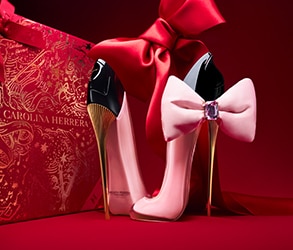 Carolina Herrera Good Girl Bowtastic parfüm rózsaszín stiletto üvegben masnival, piros ajándékdoboz és elegáns háttér